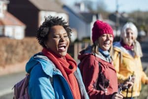 Three women dressed to go hiking laugh together
