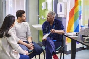 A healthcare worker discusses with two patients